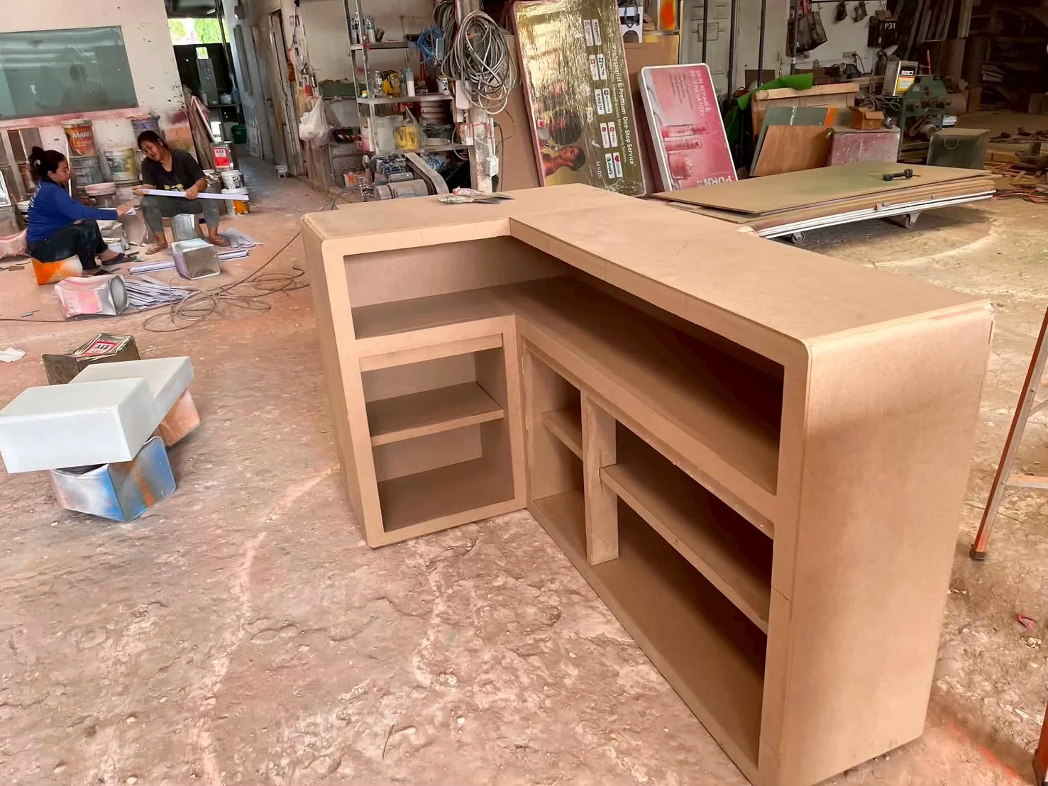 Unfinished timber reception counter with integrated shelving in the workshop